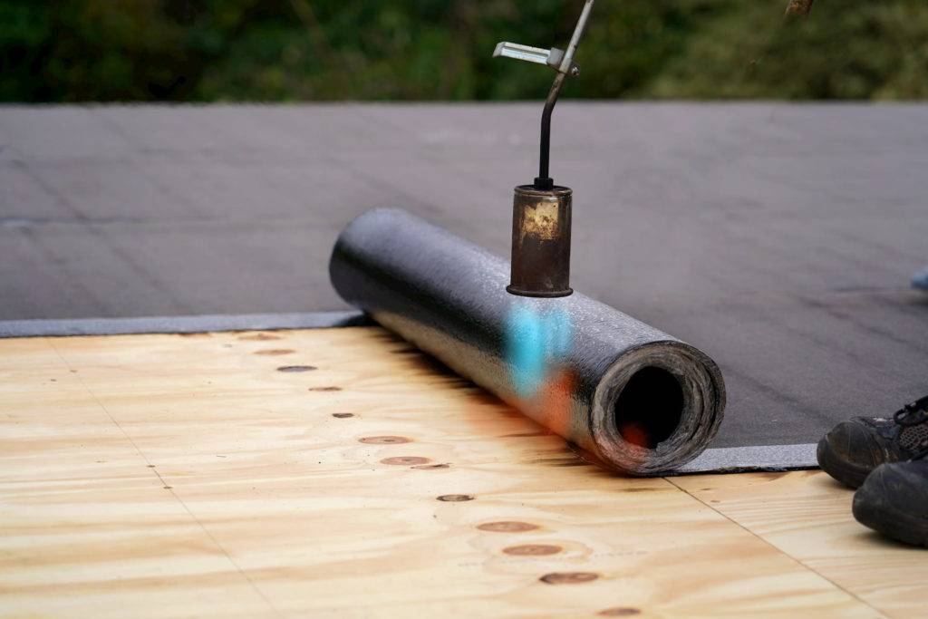 Applying roof felt with blow torch